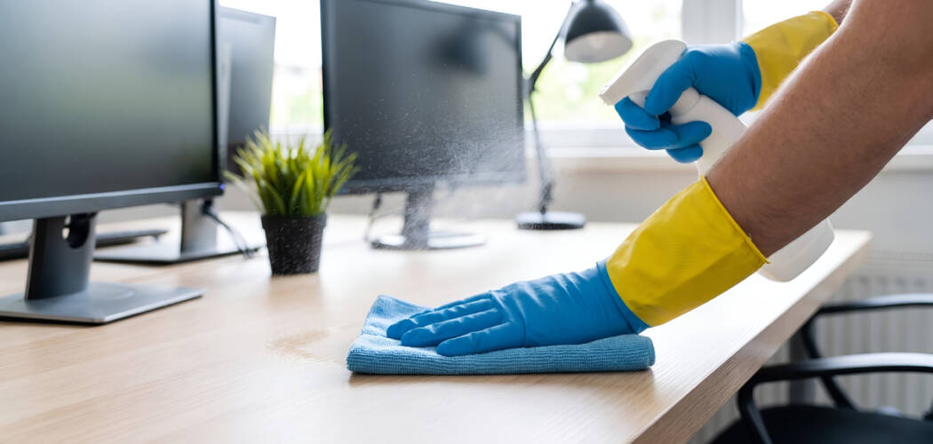 Professional janitor wiping down a wooden office desk for daily office cleaning services in Vaughan.